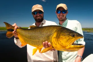 It's easy to see why these guys are smiling after catching this golden dorado