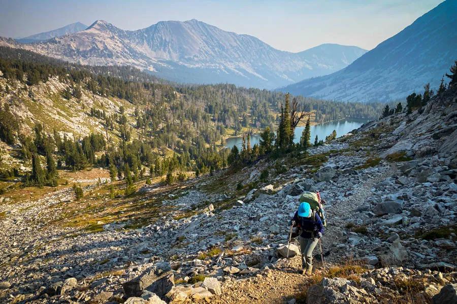 An angler ascends a ridge above a mountain lake in Southwest Montana