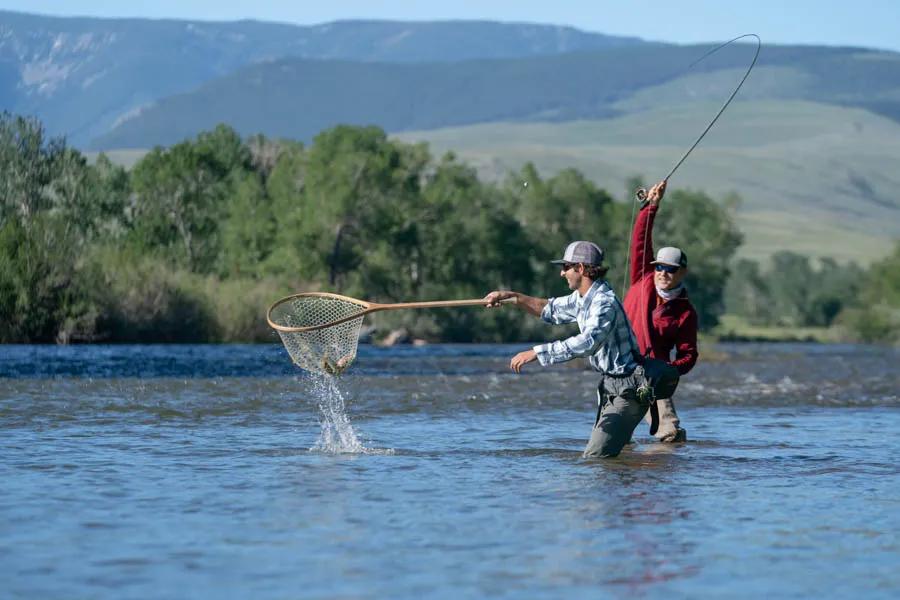 A guide helps net a rainbow trout