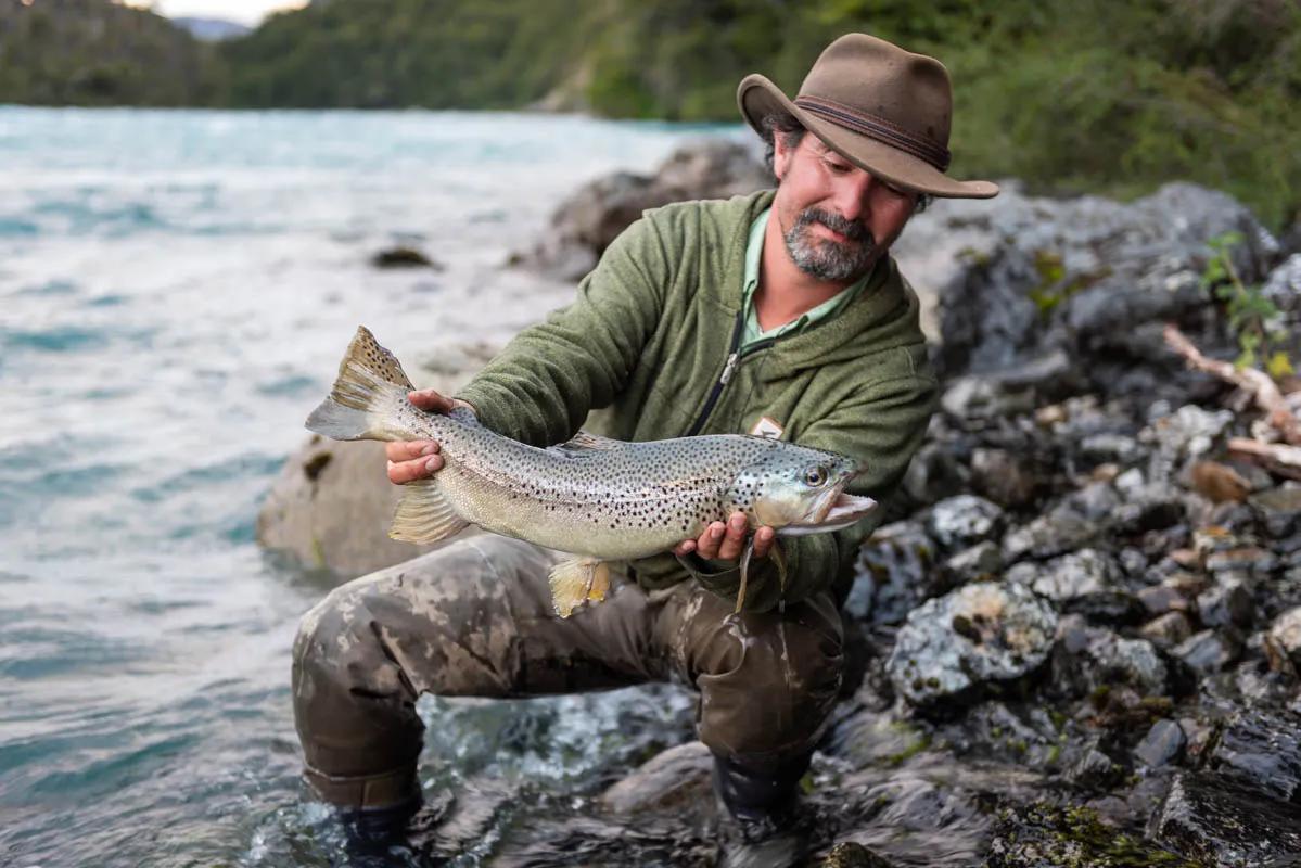 Guide Rafael holds a healthy brown trout caught below the rapids of the Rio Baker