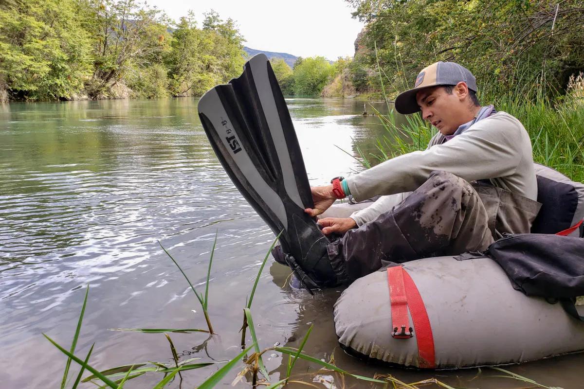 Agustin gears up with fins and a float tube to cross the Rio Cochrane