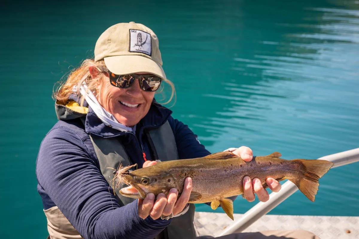 Lisa holds a nice brown trout caught on Lago Azul