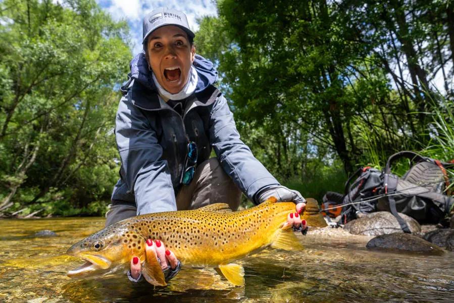 New Zealand fly fishing for big brown trout in small waters Ann celebrates after it all comes together and big brown makes it to the net.