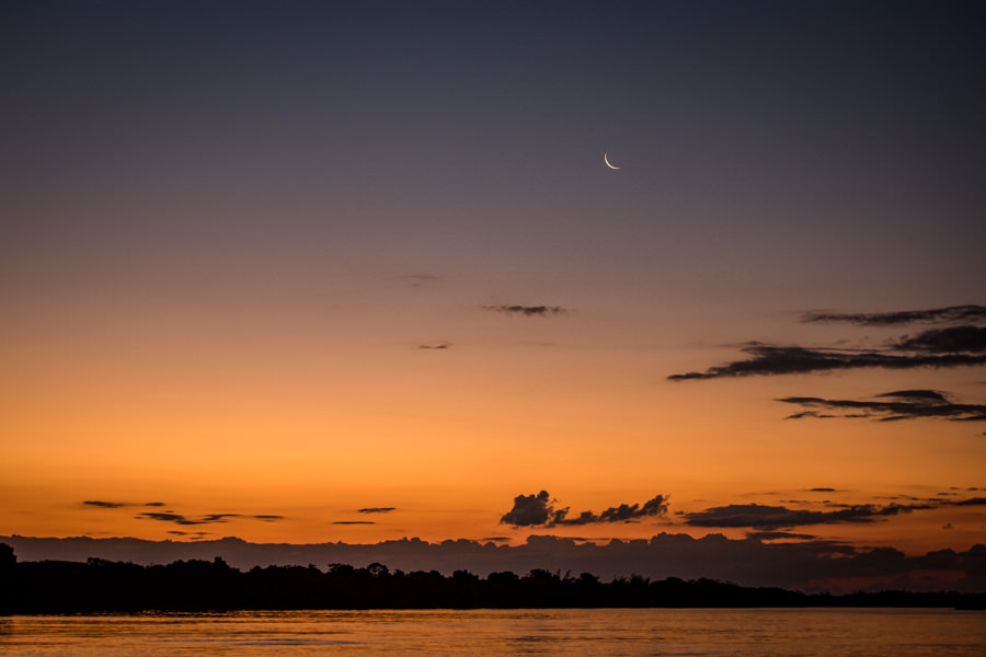 Last light and a crescent moon on Rio Parana