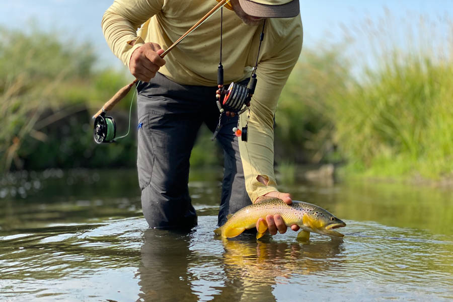 Ben Pierce holds a brown trout caught while fishing a bamboo rod