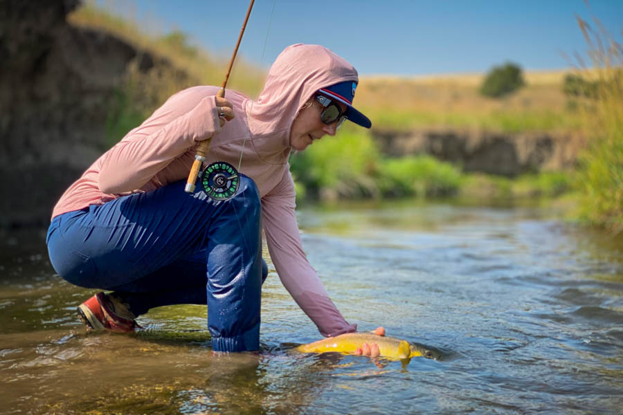 Christine Marozick releases a brown trout while fishing a small stream with a bamboo fly rod